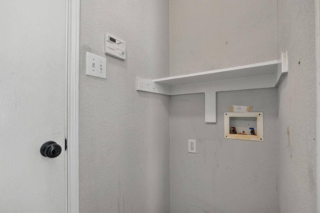 1414 Aviary Drive, DeSoto, TX 75115 Dedicated laundry space featuring a built-in white shelf, utility hookups, and electrical outlet