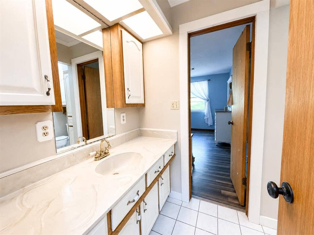 7761 Fm 2494, Athens, TX 75751 Bathroom vanity with a gold-tone faucet, integrated sink, and a large mirror