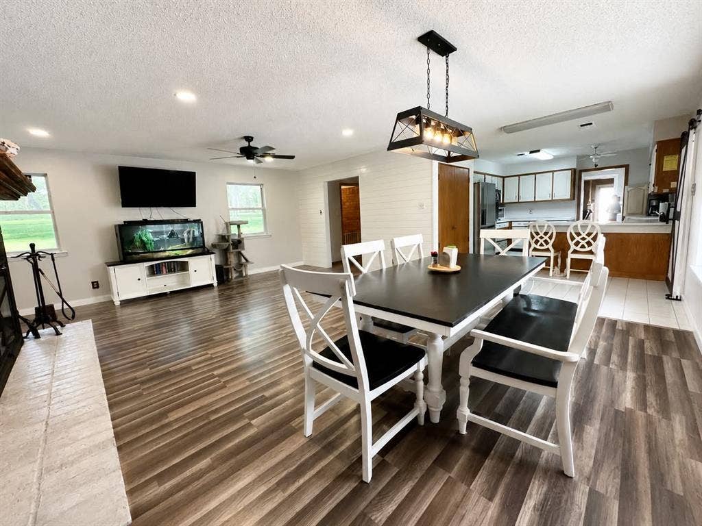 7761 Fm 2494, Athens, TX 75751 Open-concept dining area featuring a linear chandelier and wood-finish flooring