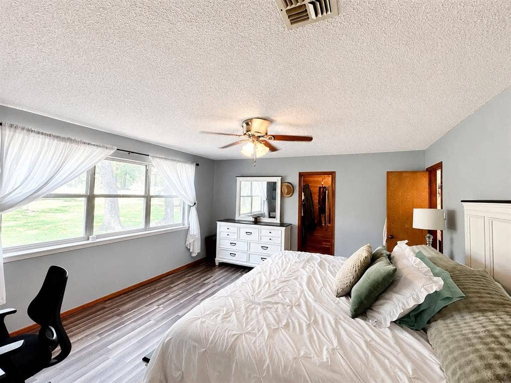 7761 Fm 2494, Athens, TX 75751 Spacious room featuring wood-finish flooring, a large window with white sheers, and light-colored walls