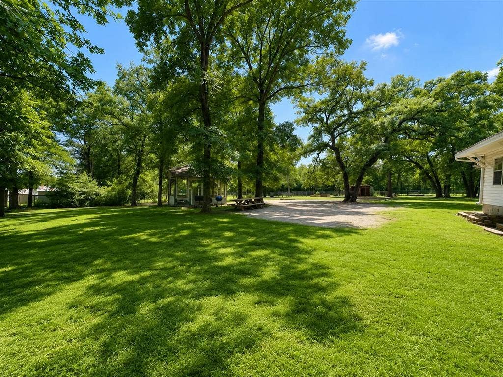 7761 Fm 2494, Athens, TX 75751 Expansive lawn with mature shade trees, a white gazebo, and a gravel parking area