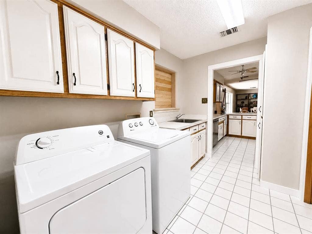 7761 Fm 2494, Athens, TX 75751 Laundry area featuring white cabinetry with wood trim, a built-in sink, and white square tile flooring