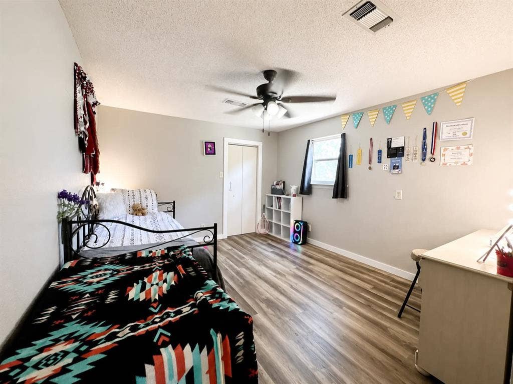 7761 Fm 2494, Athens, TX 75751 Bright room featuring wood-finish flooring, a ceiling fan with integrated lighting, and a window with dark blinds
