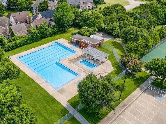 Community pool area featuring a large swimming pool, a smaller wading pool, and a trellis-covered patio