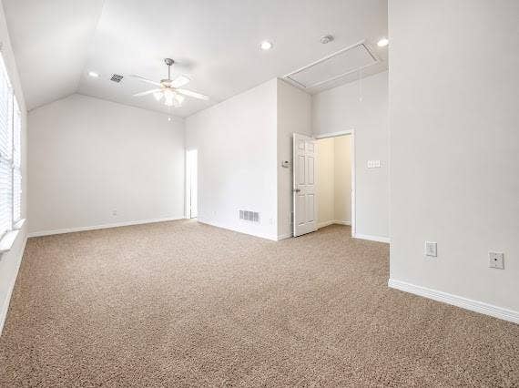 Spacious room featuring vaulted ceilings, a ceiling fan, recessed lighting, neutral carpet, and white walls