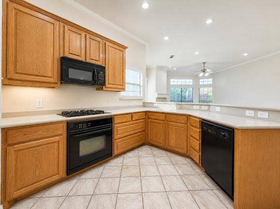 U-shaped kitchen featuring wood cabinetry, light-toned countertops, tile flooring, and recessed lighting