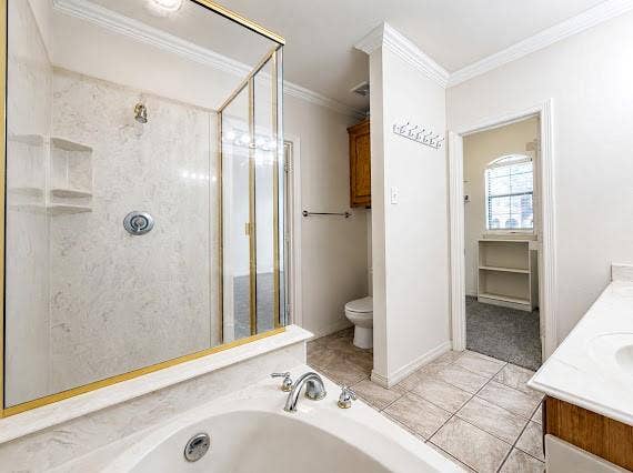 Bathroom featuring a built-in jetted tub, a glass-enclosed shower with a gold-tone frame, and an integrated shower niche
