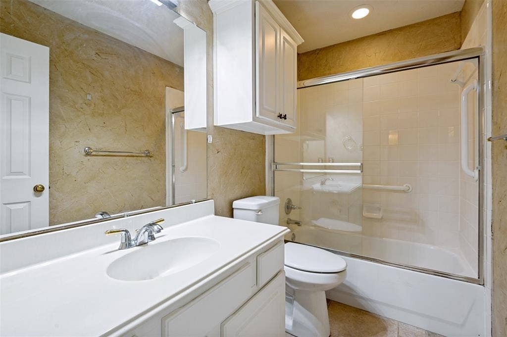 8012 Springmoss Drive, Plano, TX 75025 Full bathroom featuring a white vanity with integrated sink, chrome faucet, and overhead cabinetry