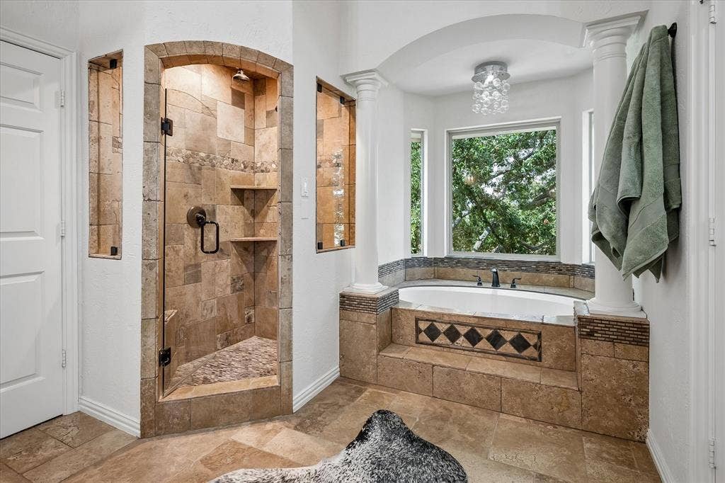 7501 Sweetgum Drive, Irving, TX 75063 Tiled walk-in shower with a glass door, built-in shelving, and a rain showerhead
