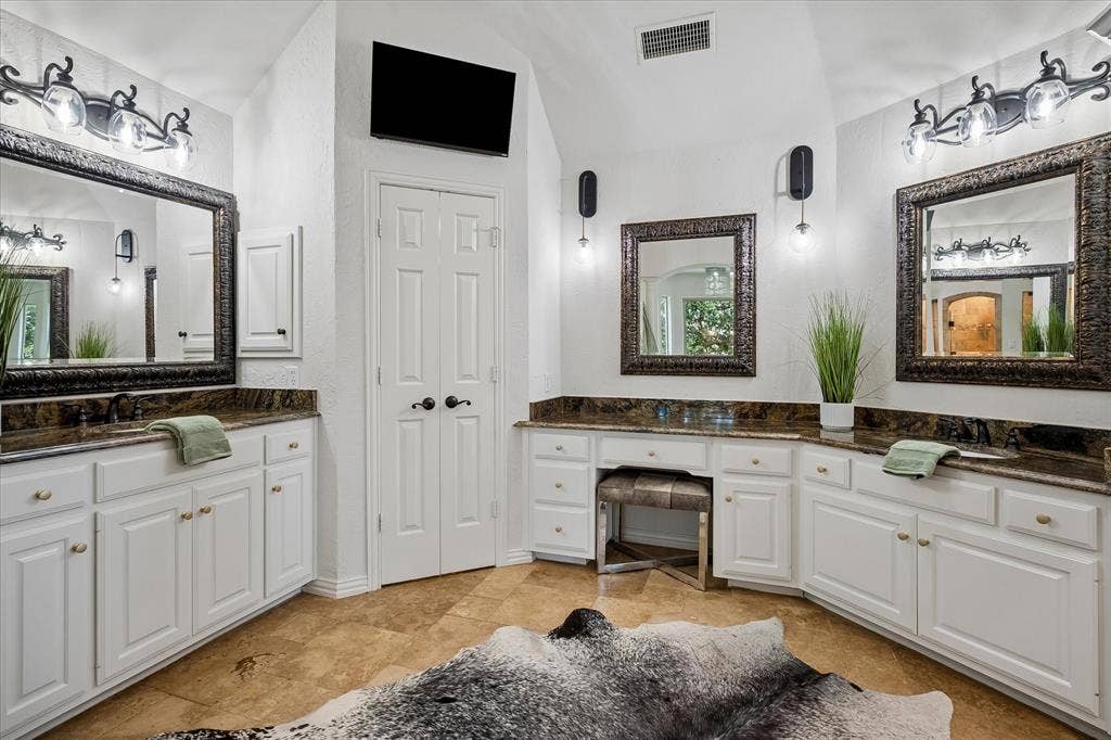 7501 Sweetgum Drive, Irving, TX 75063 Dual vanity with stone countertops, white cabinetry, and individual mirrors