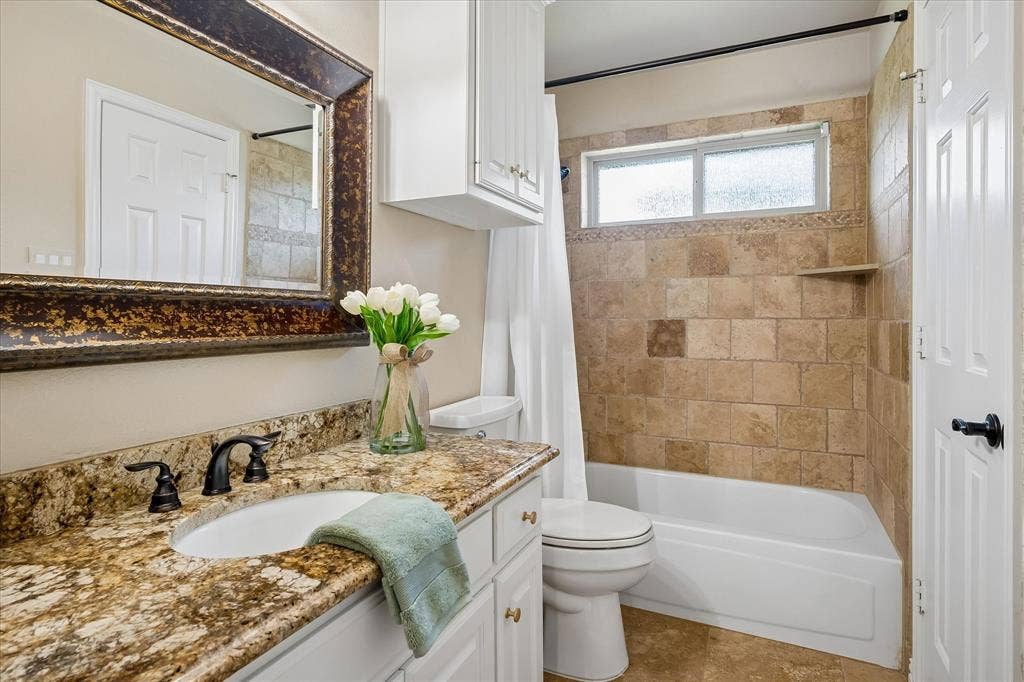 7501 Sweetgum Drive, Irving, TX 75063 Granite-finish countertop with an undermount sink and dark bronze faucet