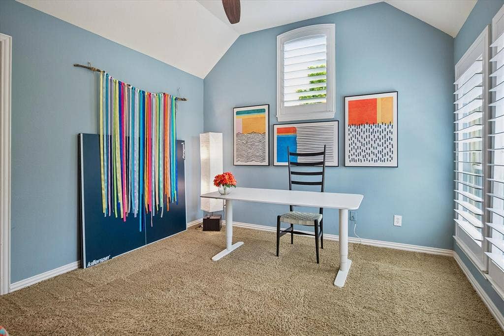 7501 Sweetgum Drive, Irving, TX 75063 Spacious room with a vaulted ceiling, ceiling fan, carpet flooring, and plantation shutters