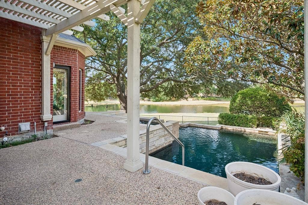 7501 Sweetgum Drive, Irving, TX 75063 Red brick exterior with an attached pergola and an exposed aggregate patio