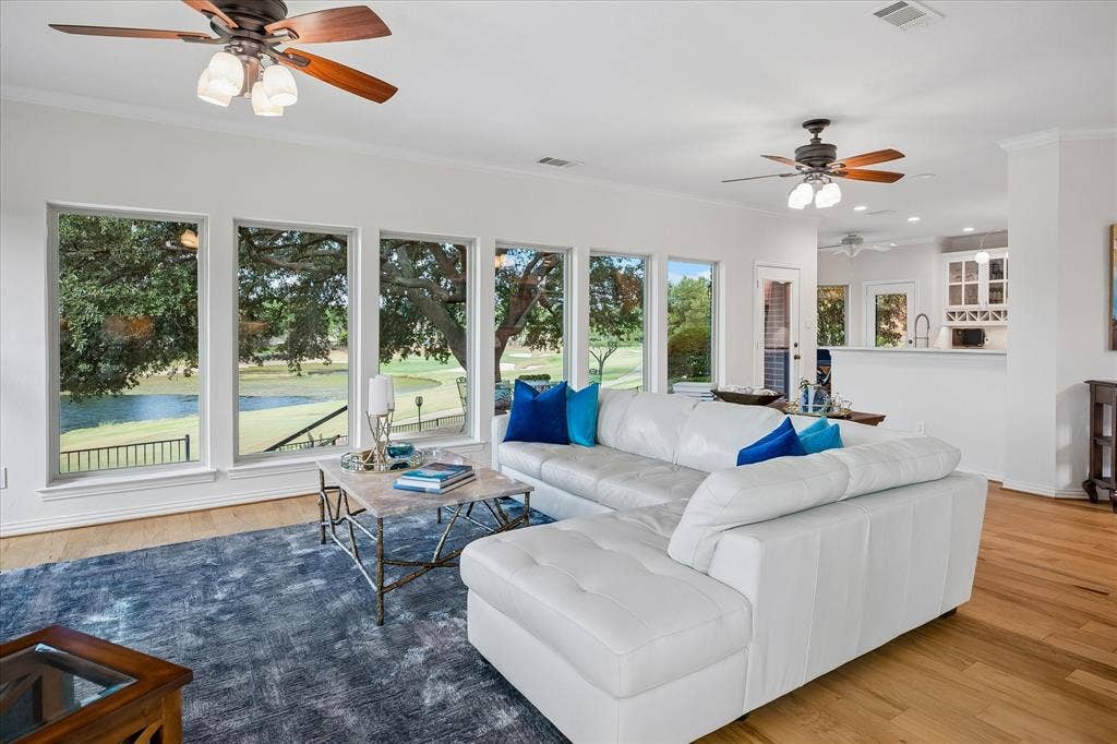 7501 Sweetgum Drive, Irving, TX 75063 Expansive living space featuring wood-finish flooring, a wall of multiple windows, and recessed lighting