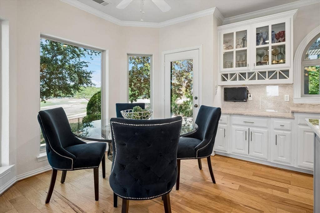 7501 Sweetgum Drive, Irving, TX 75063 Hardwood flooring, abundant natural light, built-in cabinetry with glass fronts, integrated wine storage, and a transom window