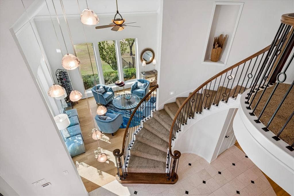 7501 Sweetgum Drive, Irving, TX 75063 Grand curved staircase with wrought iron balusters and wood handrail