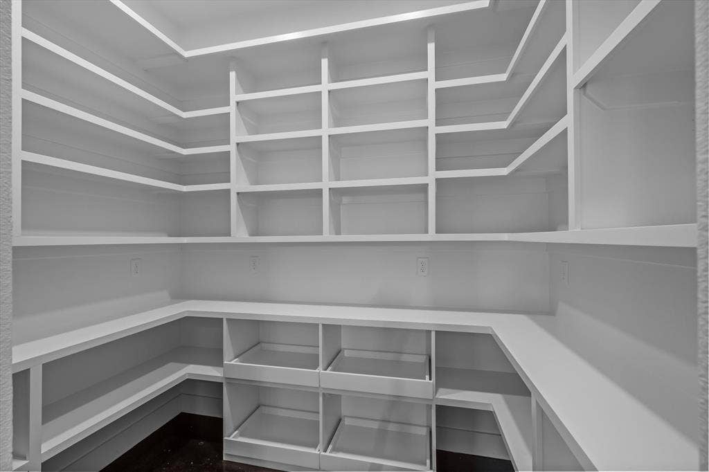 12253 Madison Xing, Bullard, TX 75757 Walk-in pantry featuring white shelving, built-in lower storage, and dark wood-finish flooring