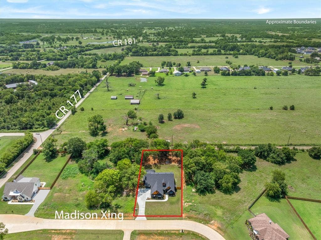 12253 Madison Xing, Bullard, TX 75757 Aerial perspective showcasing a property outlined in red, featuring a single-story residence with a dark roof and light-colored driveway