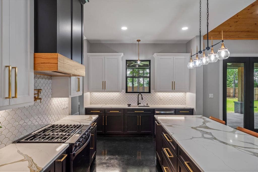 12253 Madison Xing, Bullard, TX 75757 Spacious kitchen featuring a gas range, large center island with seating, dark lower cabinetry, and white upper cabinetry