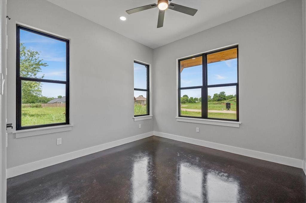 12253 Madison Xing, Bullard, TX 75757 Spacious room featuring multiple large windows with black frames, offering expansive views of surrounding green space