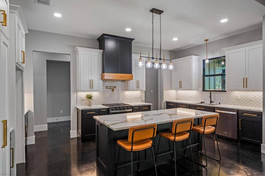 12253 Madison Xing, Bullard, TX 75757 Kitchen featuring a large island with a patterned countertop, two-tone cabinetry, a tile backsplash, dark wood-finish flooring, and recessed lighting