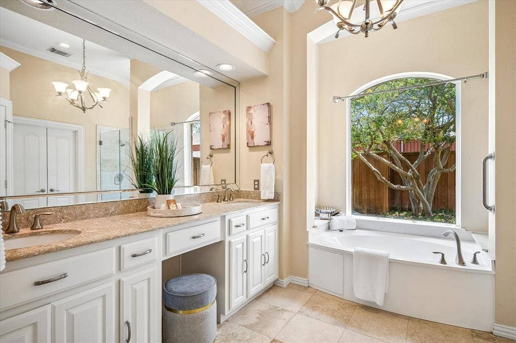 6708 Myrtle Beach Drive, Plano, TX 75093 Primary bathroom with garden tub and picture window overlooking backyard.