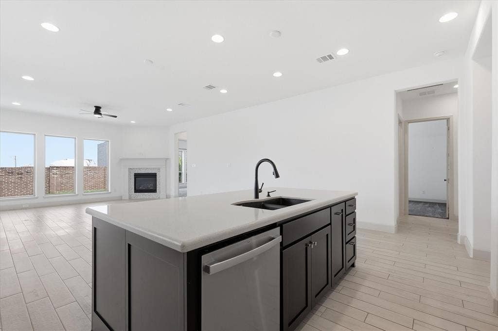 787 Cedarwood Court, Haslet, TX 76052 Kitchen island featuring a single-basin sink with a matte black faucet and a stainless steel dishwasher