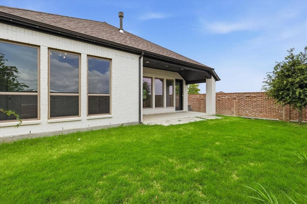 787 Cedarwood Court, Haslet, TX 76052 Spacious backyard featuring a covered patio with concrete flooring, a lush green lawn, and a privacy brick fence
