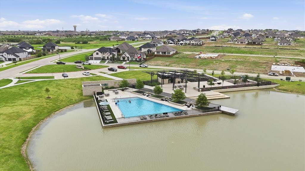 787 Cedarwood Court, Haslet, TX 76052 Community pool area featuring a rectangular swimming pool with surrounding lounge seating, a dock extending into the lake, and a covered patio structure with pergolas
