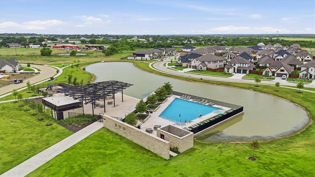 787 Cedarwood Court, Haslet, TX 76052 Resort-style community pool with surrounding lounge chairs, an adjacent covered patio area, and a stone-clad building