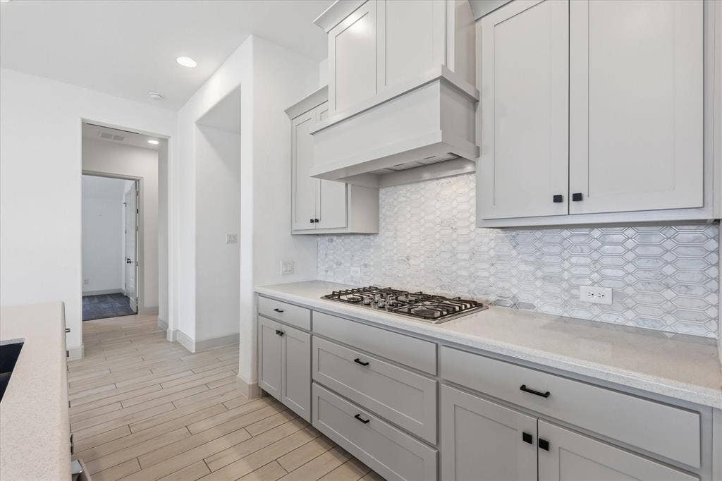 787 Cedarwood Court, Haslet, TX 76052 Modern kitchen featuring light gray cabinetry, a built-in gas cooktop, and a decorative range hood