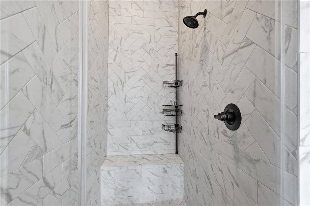 787 Cedarwood Court, Haslet, TX 76052 Shower stall featuring herringbone-patterned tile, integrated bench seating, and matte black fixtures