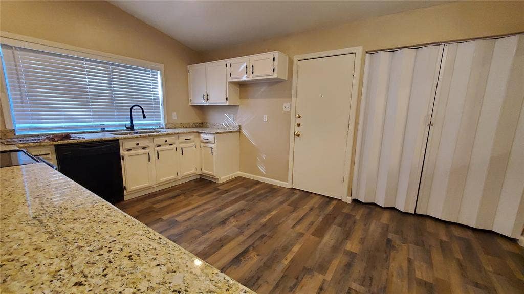 8440 Willow Creek Drive, Frisco, TX 75034 Kitchen with white cabinets, dark hardwood / wood-style flooring, lofted ceiling, and black appliances and smooth surface range.