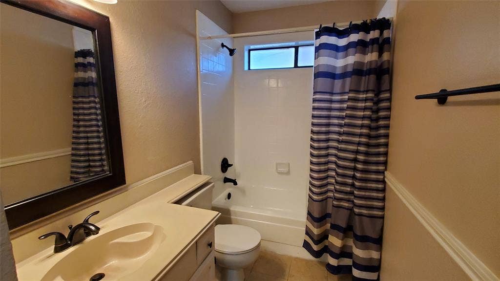 8440 Willow Creek Drive, Frisco, TX 75034 Full bathroom featuring tile patterned flooring, vanity, shower / tub combo with curtain, and toilet