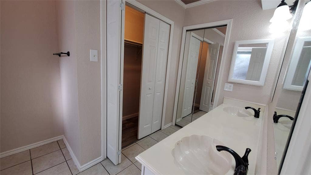 8440 Willow Creek Drive, Frisco, TX 75034 Bathroom with tile patterned flooring, vanity, dual closet space, and ornamental molding