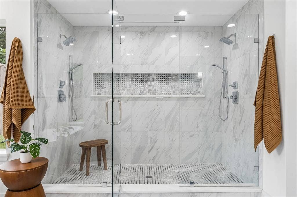 7124 Meadow Road, Dallas, TX 75230 Oversized frameless shower in primary with bench and niche