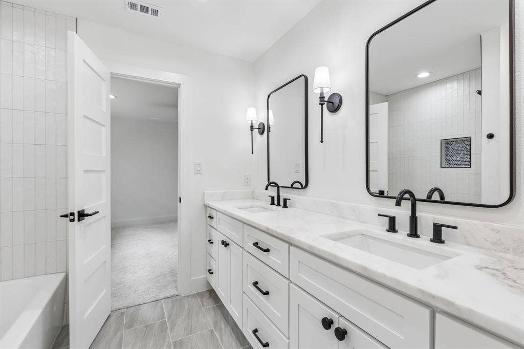 7124 Meadow Road, Dallas, TX 75230 Jack and jill bathroom includes bathrub,dual sinks,and plenty of storage