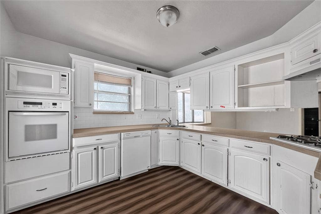600 Terrace Drive, DeSoto, TX 75115 Kitchen featuring white cabinetry and built-in appliances, wood-finish flooring, a wall oven and microwave combination, a built-in dishwasher, and a gas cooktop