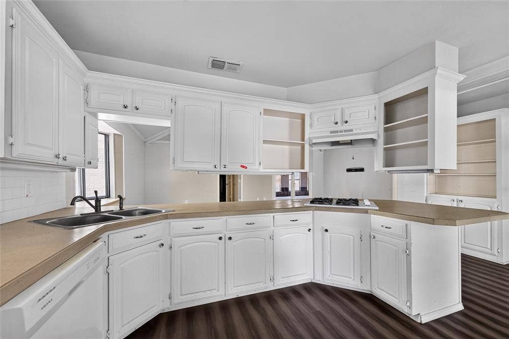 600 Terrace Drive, DeSoto, TX 75115 Kitchen featuring white cabinetry, light-toned countertops, a double basin sink with a dark-finish faucet, a stovetop, and wood-finish flooring