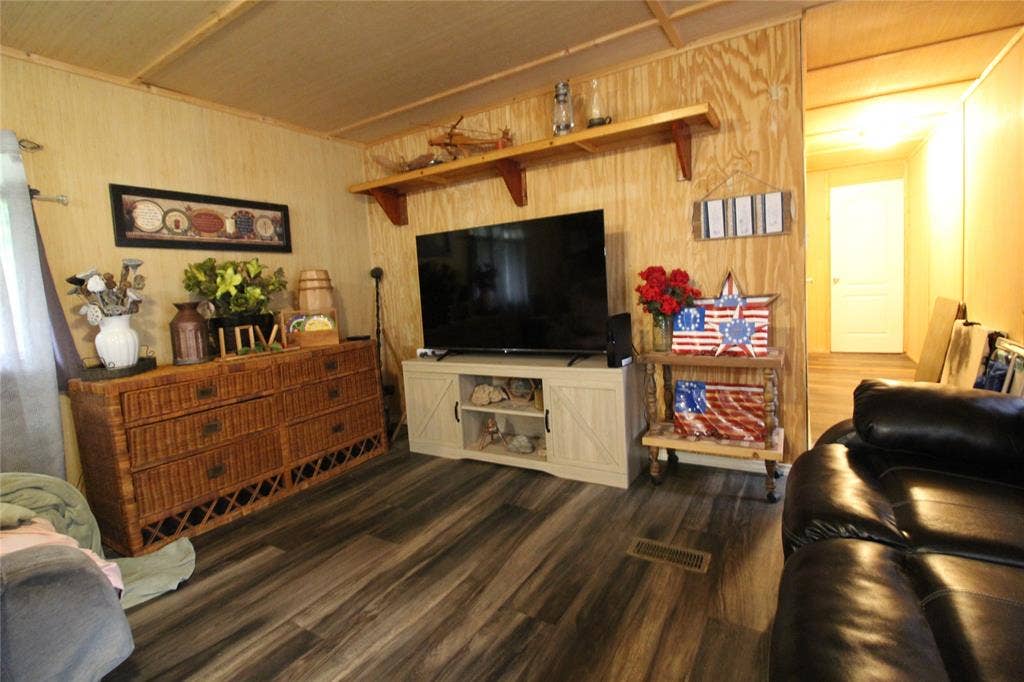 921 Crown Drive, Tool, TX 75143 Interior space featuring wood-finish flooring, wood paneling, and a built-in shelf