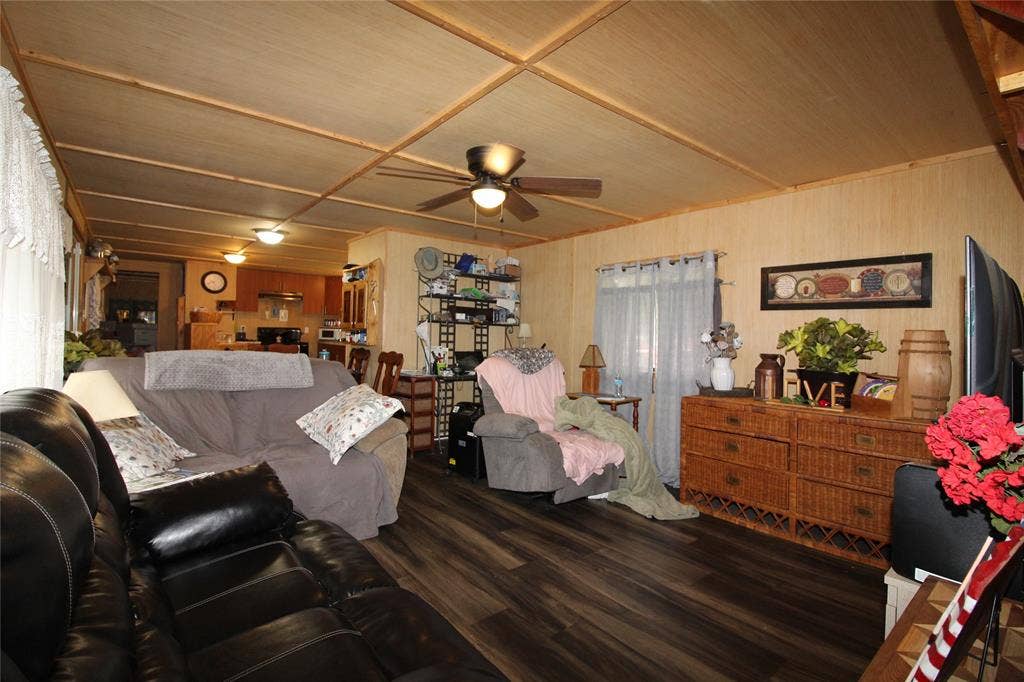 921 Crown Drive, Tool, TX 75143 Spacious living area featuring wood-finish flooring, paneled walls, and a wood-paneled ceiling with exposed beams