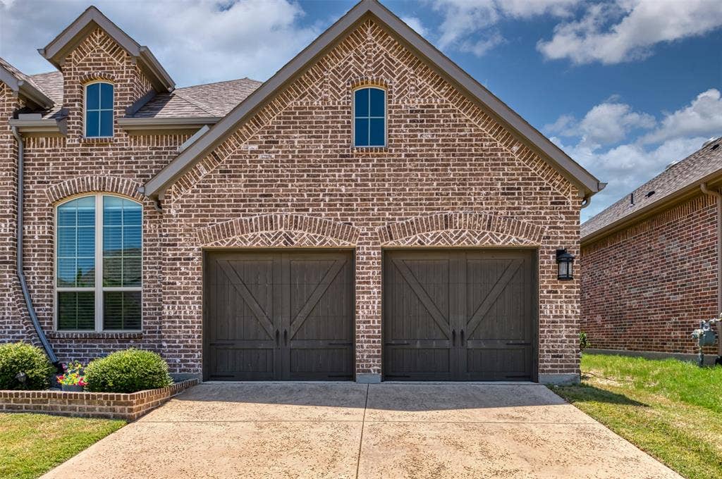 1109 10th Street, Argyle, TX 76226 Brick facade with arched window and two carriage-style garage doors