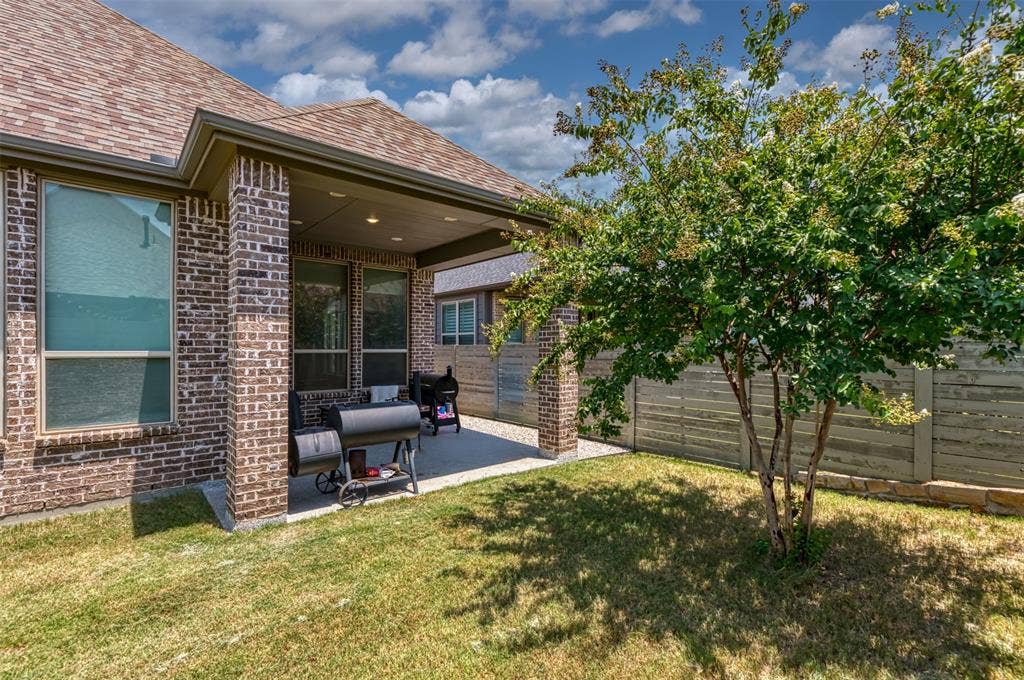 1109 10th Street, Argyle, TX 76226 Covered patio featuring a concrete surface, brick support columns, and an exterior brick wall