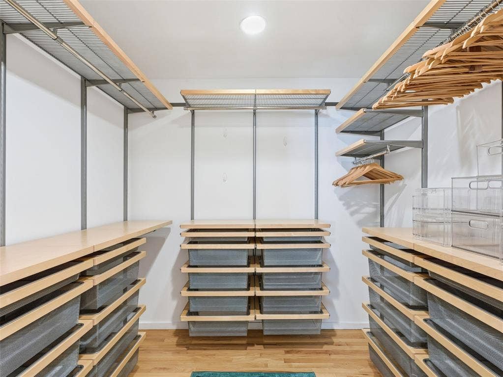 Customized closet system featuring light wood-finish shelving and integrated wire baskets
