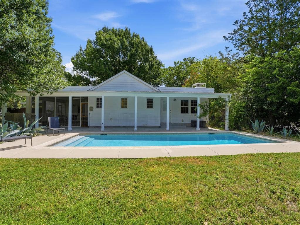 Rectangular swimming pool with integrated steps, surrounded by a concrete patio