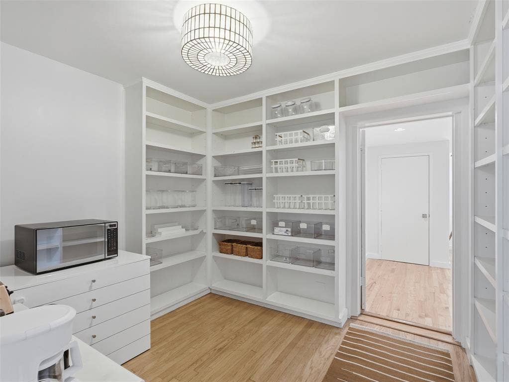 Built-in shelving with extensive storage, wood-finish flooring, and recessed lighting