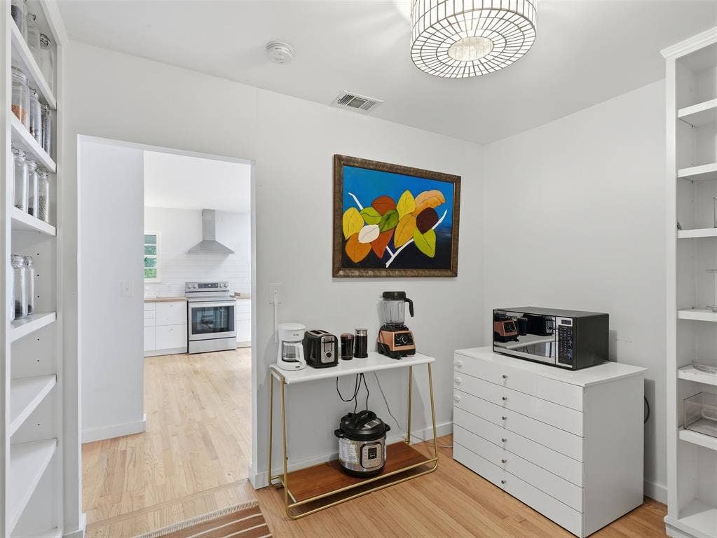Hardwood-style flooring throughout this space with built-in shelving, providing extensive storage