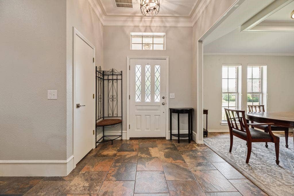 419 N Winding Oaks Drive, Wylie, TX 75098 Foyer featuring natural stone tile flooring, a white paneled entry door with decorative glass inserts, and a transom window