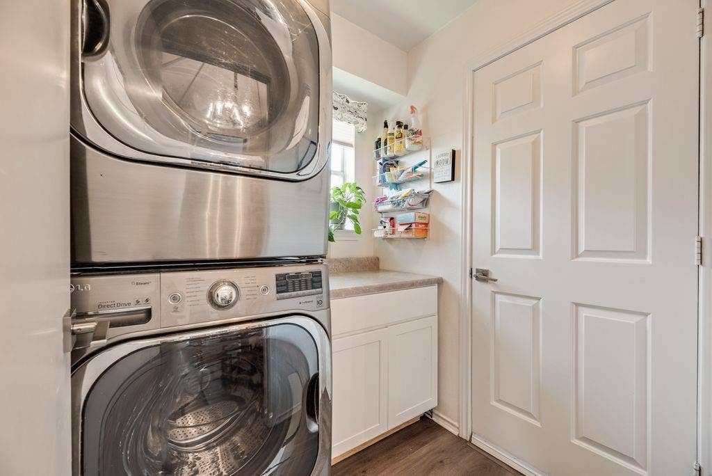 419 N Winding Oaks Drive, Wylie, TX 75098 Stackable laundry appliances, white cabinetry, and a countertop surface with a window above