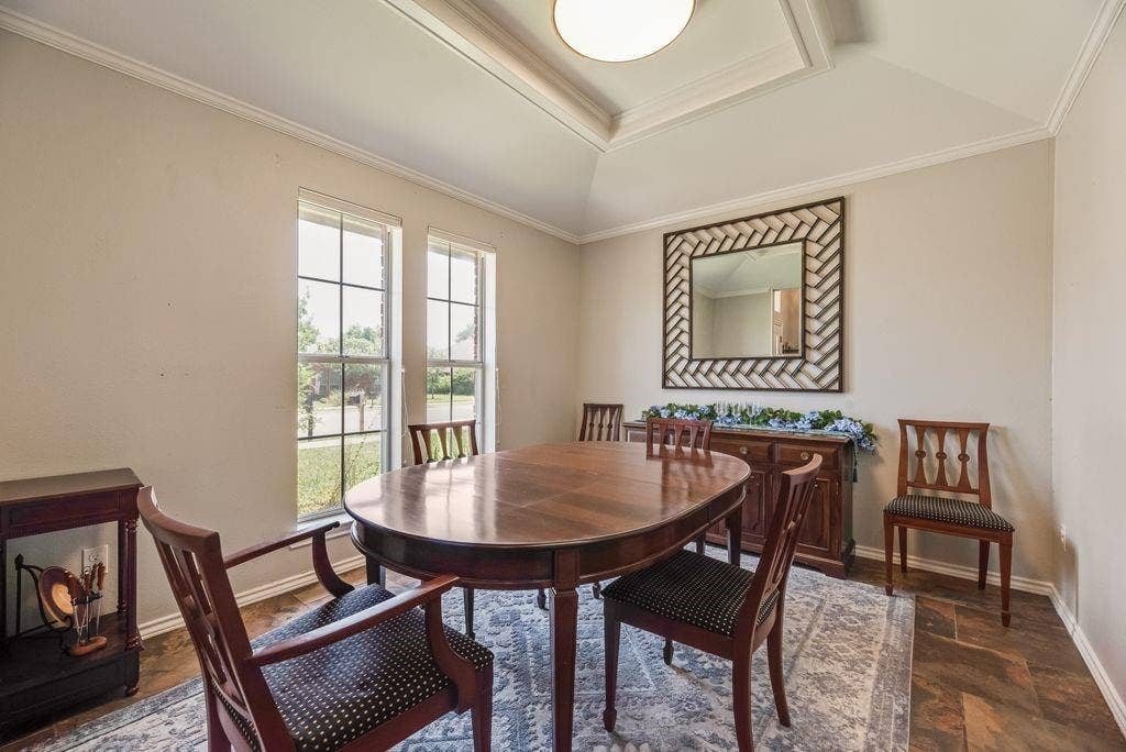 419 N Winding Oaks Drive, Wylie, TX 75098 Dining area featuring wood-finish flooring, two large windows, a tray ceiling with crown molding, and a built-in buffet with a stone top